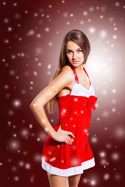 Beautiful girl dressed as Santa Claus on Christmas background — Stock Photo, Image