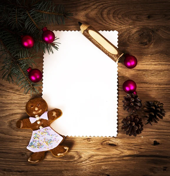 Hoja de papel en blanco en el suelo de madera con un lápiz y decoraciones de Navidad Imagen De Stock