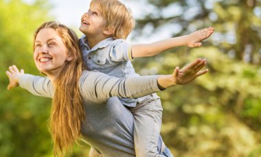güneşli bir parkta mutlu anne ve oğlu geri kalan
