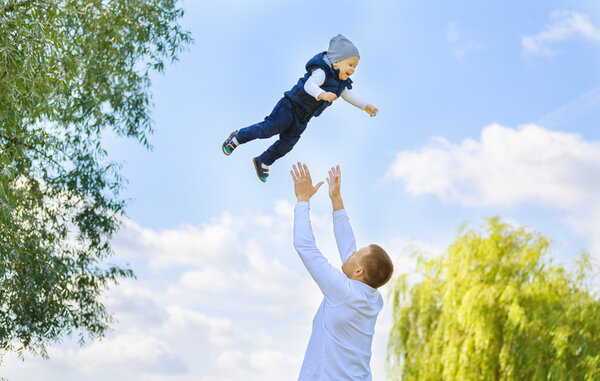 Счастливые отец и сын на прогулке в солнечный день
