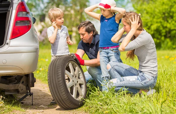 Trevlig familj byter däck på bilen — Stockfoto