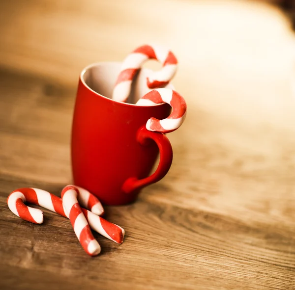 Caneca de chá ou café. Doces. Decorações de Natal. Bolas e Sinos Vermelhos. Fundo de madeira . — Fotografia de Stock