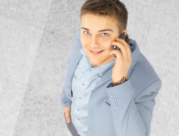 Glücklicher erfolgreicher junger Geschäftsmann, der mit dem Handy spricht — Stockfoto