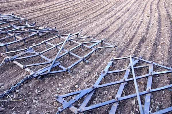 Agriculture machinery harrow rake on plowed field — Stock Photo, Image