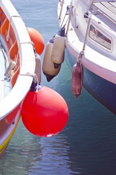 Close up of boats standing besides each other with buoys — Stock Photo, Image