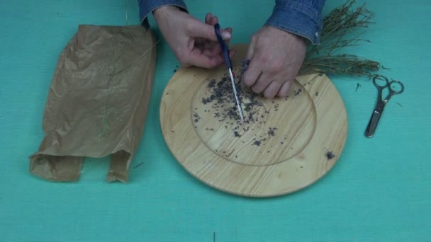 Man snijden gedroogde lavendel in een houten kom — Stockvideo