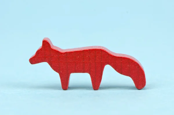 Mały drewniany red fox zabawka na niebieskim tle — Zdjęcie stockowe
