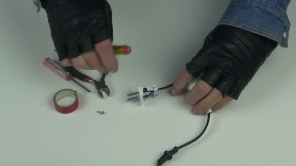 Человек в черных перчатках, чинит электрическую розетку — стоковое видео