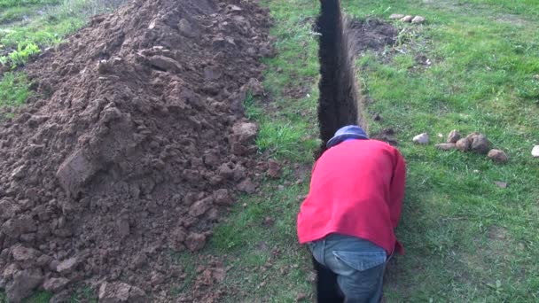 Ο άνθρωπος σκάψιμο μια πολύ στενή τάφρο — Αρχείο Βίντεο