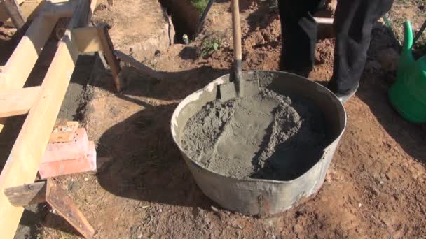 Mężczyzna robotnik łopatą beton cement do wiadra — Wideo stockowe
