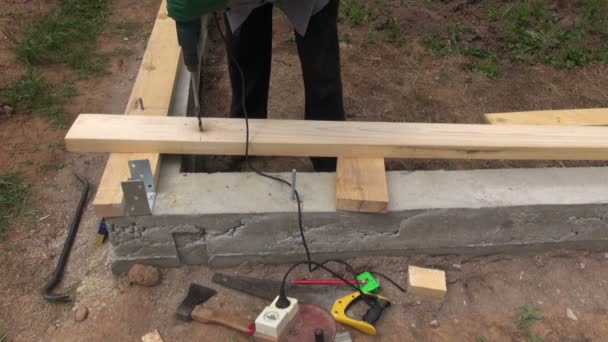 Man voorbereiding van houten planken op de Stichting vast te stellen — Stockvideo