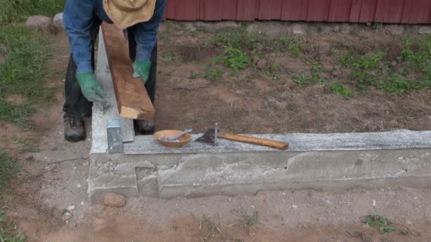 Costruttore ponendo assi di legno su fondamenta di cemento — Video Stock