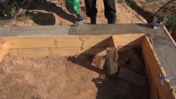 Verter agua sobre cimientos de cemento y hormigón — Vídeo de stock