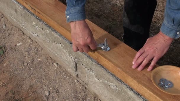 Construtor fixação prancha de madeira na fundação da casa — Vídeo de Stock