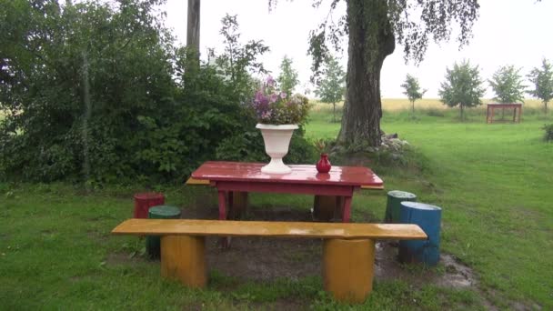 Lluvia cayendo sobre la mesa al aire libre — Vídeos de Stock