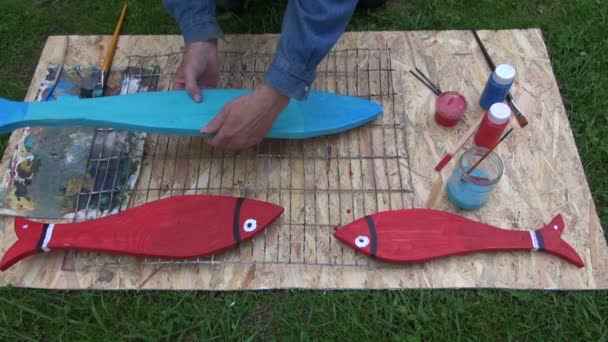 Artista pintando peces de madera — Vídeos de Stock