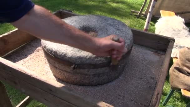 Moliendo trigo con piedra de molino en feria medieval — Vídeo de stock