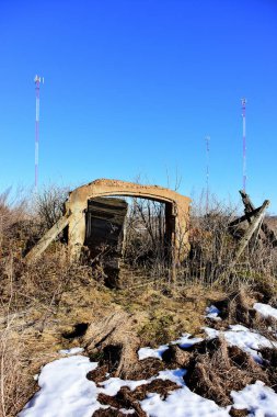 Kırmızı beyaz metalik iletişim sütunları ve tarihi ahır kalıntıları