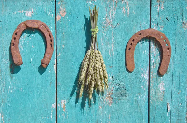 Cacho de trigo e dois símbolo de sorte ferradura na parede do celeiro de madeira — Fotografia de Stock