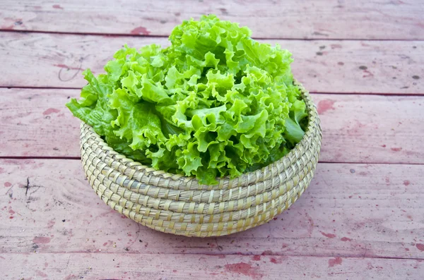 Fresh green lettuce in wicker plate — Stock Photo, Image