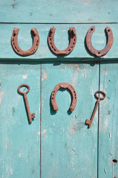 Antique fer à cheval et clé rouillée sur vieille porte en bois — Photo