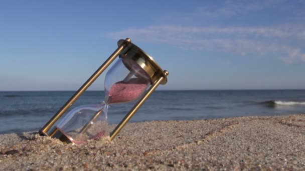 Relógio de areia de ampulheta de bronze antigo na areia da praia do mar — Vídeo de Stock