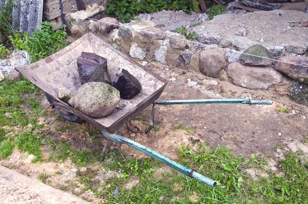 Lugar de trabalho com carrinho de mão e pedra na fazenda — Fotografia de Stock