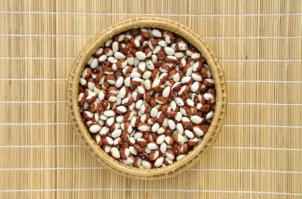 Wicker plate with grains beans — Stock Photo, Image