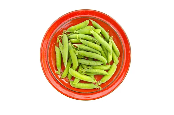 Fresh pea pods in red ceramic plate — Stock Photo, Image