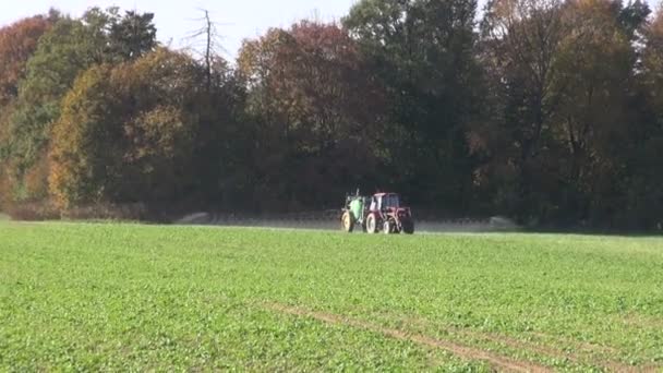 Traktor, rozprašování hnojiv pesticidů na statku pole