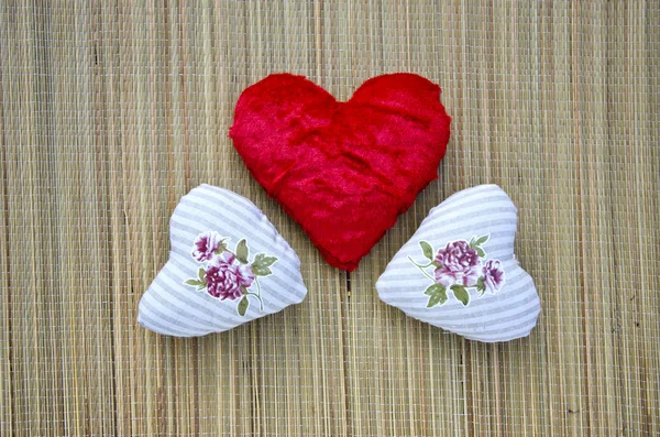 Три красивых тканных сердечка на столе — стоковое фото