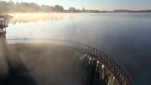 Diga del lago con spruzzi d'acqua e nebbia mattutina — Video Stock