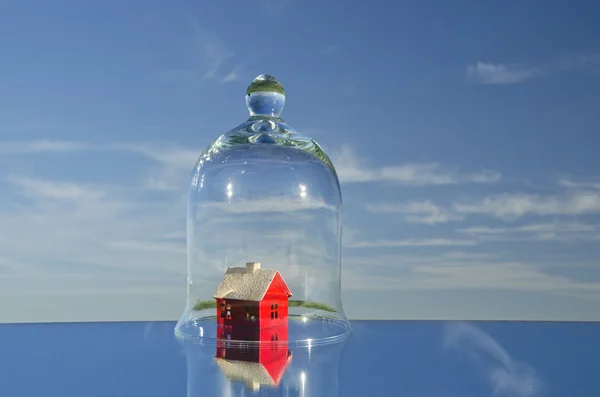 Kleine rode huis model in glas bell op de spiegel in de ruimte — Stockfoto