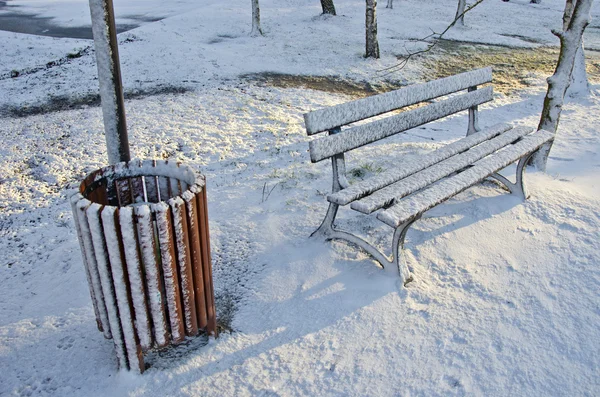 Śmieci pudełko i drewniane ławki w winter park — Zdjęcie stockowe