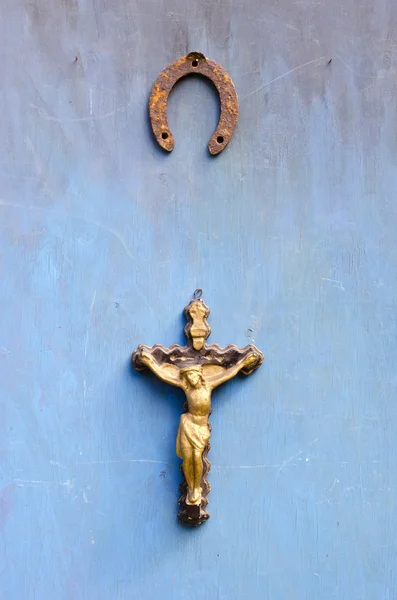 Suffering of Jesus Christ crucifixion and rusty horseshoe on old blue  wall — Stock Photo, Image