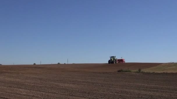 Moderne landbouw trekker zaaien naaien gewas graan op boerderij veld — Stockvideo