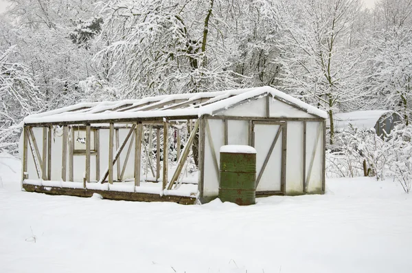 Invernadero de plástico cubierto de nieve en pleno jardín de la granja de invierno — Foto de Stock