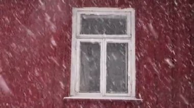 Kar yağışı ve ahşap köy evi penceresinde