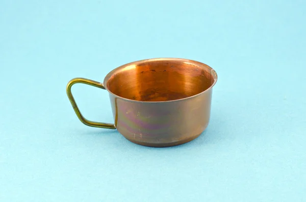 Old antique brass cup on blue background — Stock Photo, Image