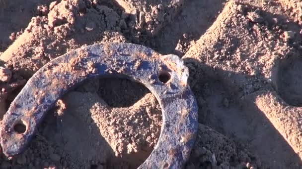 Retro rusty horseshoe and  tractor traces on farm field soil — Stock Video