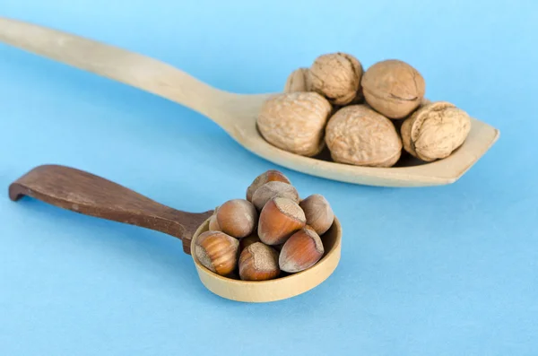 Alimentos saludables avellanas y nueces en cucharas de madera —  Fotos de Stock