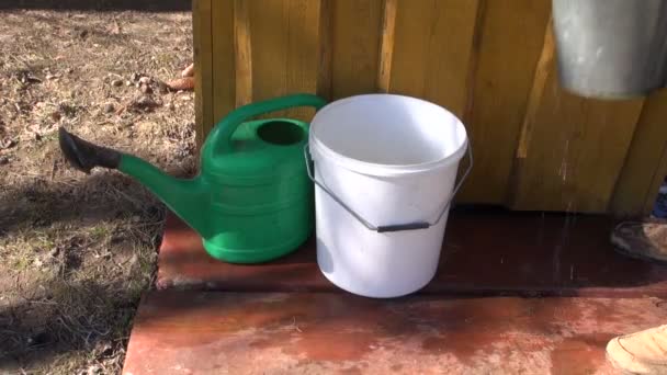 Gärtner schüttet Wasser in Plastikeimer — Stockvideo