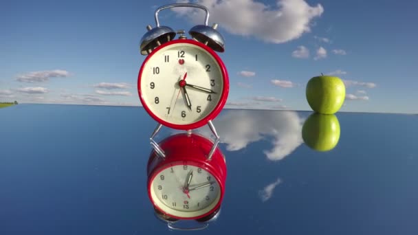 Ретро аналоговый будильник стрелка движения и яблоко на зеркале. Timelapse 4K — стоковое видео