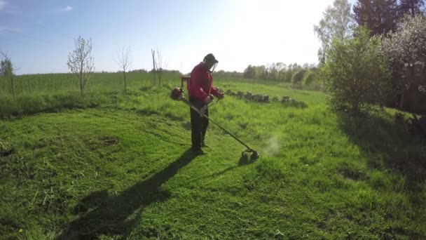 Rolnik koszenie trawy z trymer kosiarka na wiosnę. Timelapse 4 K — Wideo stockowe