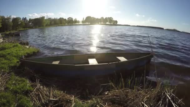 Старая деревянная рыболовная лодка на озерной воде весной. — стоковое видео