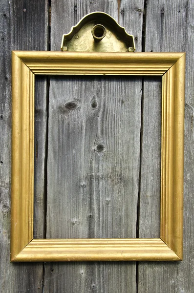 Vintage golden wooden picture frame on old wooden wall — Stock Photo, Image