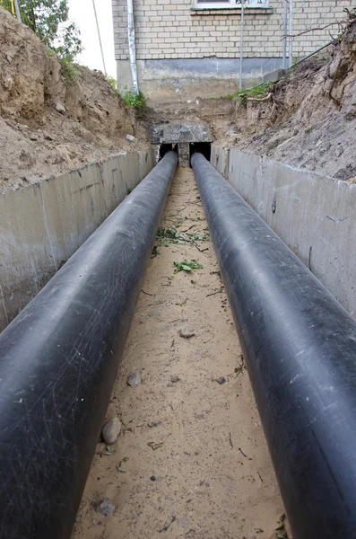 New plastic modern heating pipes in trench near city house — Stock Photo, Image