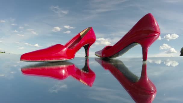 Pair red woman shoe stilettos on mirror and clouds motion. Fashion concept. Timelapse 4K — Stock Video