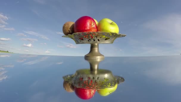 Vintage vase with fruits on mirror and sky clouds motion. Timelapse 4K — Stock Video