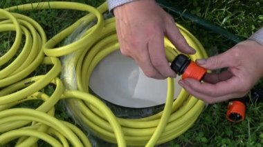 iki elle su hortumu kavşak çimenlerin üzerinde hazırlanıyor